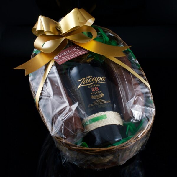 Foto de una canasta que contiene media botella de Ron Zacapa Centenario y 12 vasitos de chocolate.