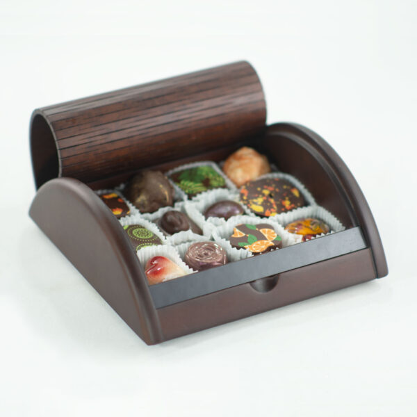 caja de madera estilo roll top abierta enseñando bombones de chocolate